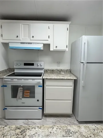 a kitchen with white cabinets and white appliances