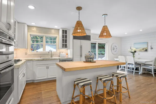 a large white kitchen with a white wooden cabinets and stainless steel appliances