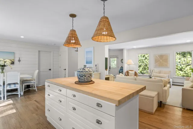 a kitchen with stainless steel appliances granite countertop a sink a stove and a dining table with wooden floor