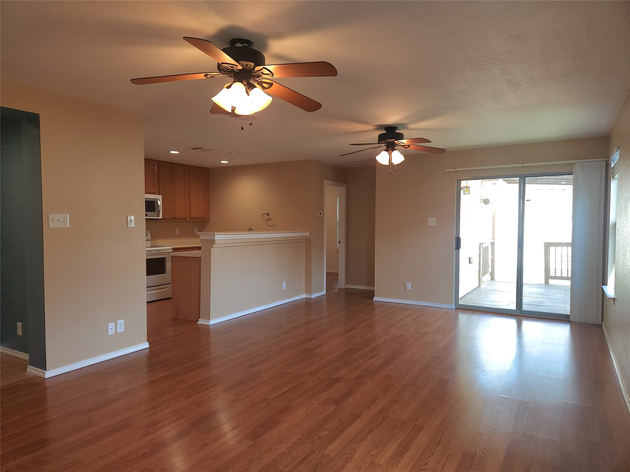 273 Tower Drive Kyle, TX 78640 - Photo 2 of 13 a view of an empty room with wooden floor and a kitchen