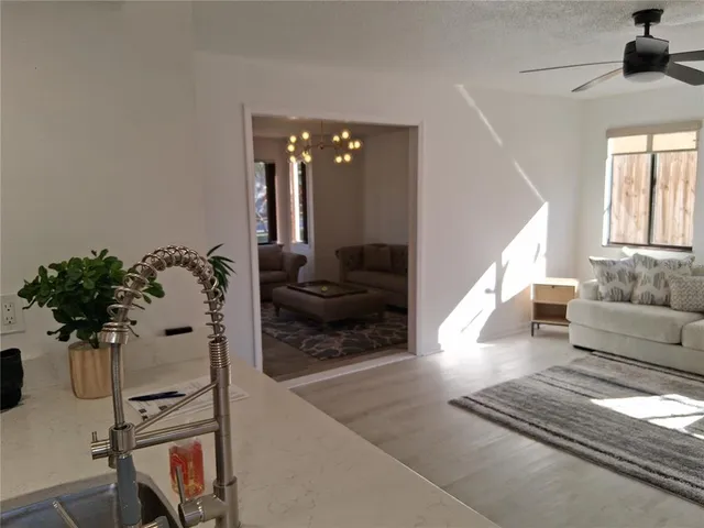 a living room with furniture a wooden floor and a chandelier