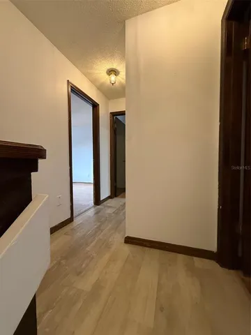 an empty room with wooden floor and mirror