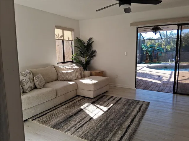 a view of an empty room with glass door and wooden floor