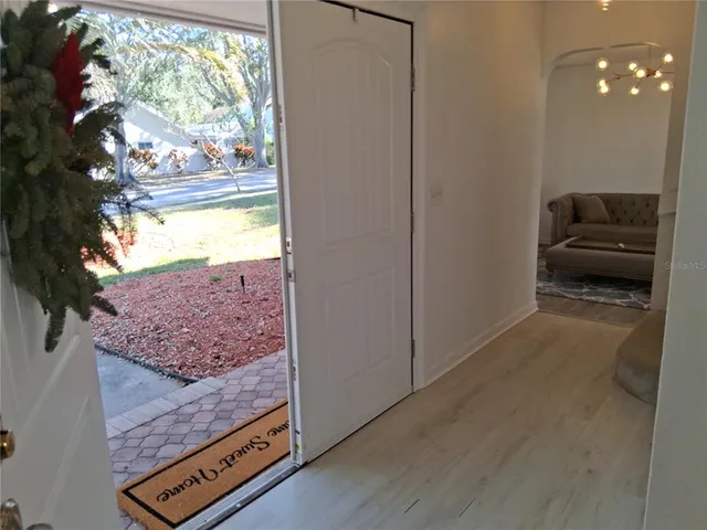 a view of a room with wooden floor and a floor to ceiling window