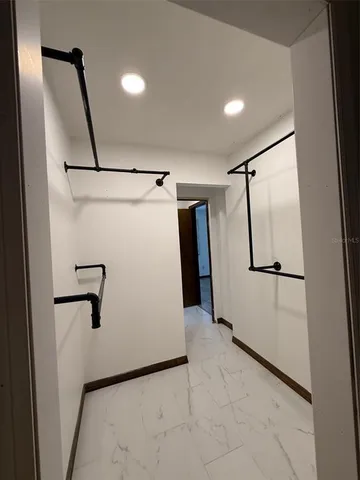 an empty room with wooden floor and mirror