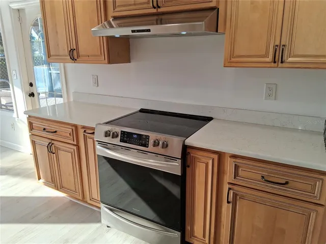 a kitchen with stainless steel appliances granite countertop a stove a sink and a refrigerator