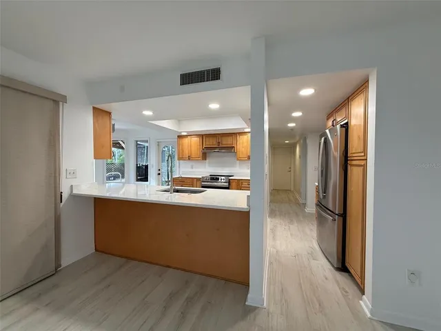 a view of an empty room with glass door and wooden floor