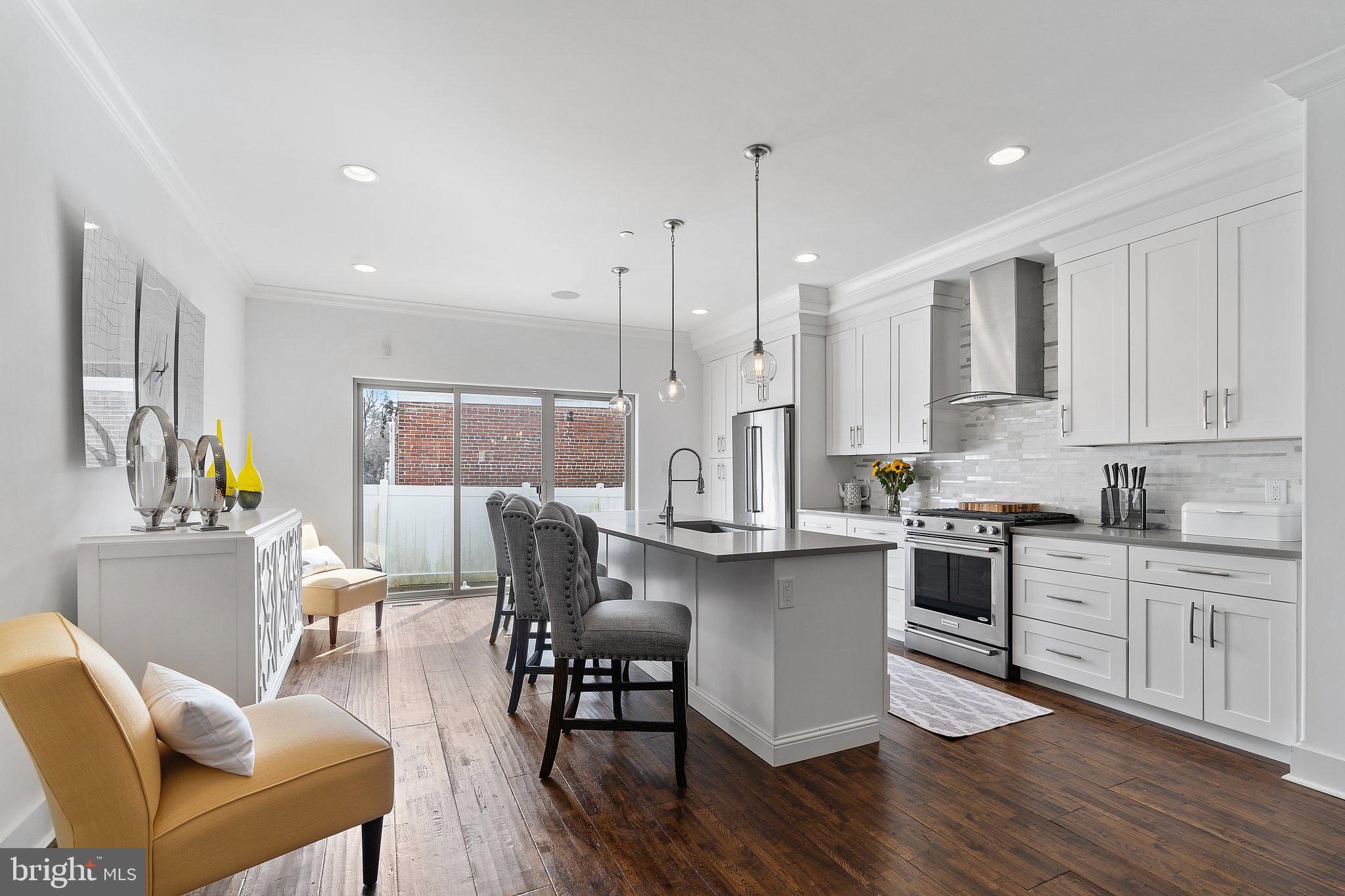 329 Delmar Street Philadelphia, PA 19128 - Photo 3 of 20 a kitchen with stainless steel appliances granite countertop a table chairs stove a sink dishwasher and cabinets