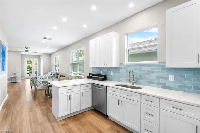 a kitchen with a sink stove cabinets and wooden floor