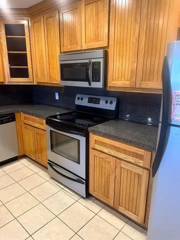 a kitchen with granite countertop a stove top oven cabinetry a sink and a microwave