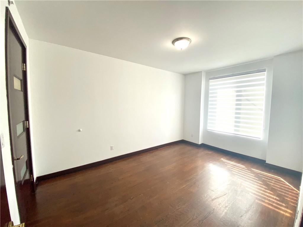 2409 Avenue Z, Unit 202 Brooklyn, NY 11235 - Photo 12 of 26 a view of an empty room with wooden floor and a window
