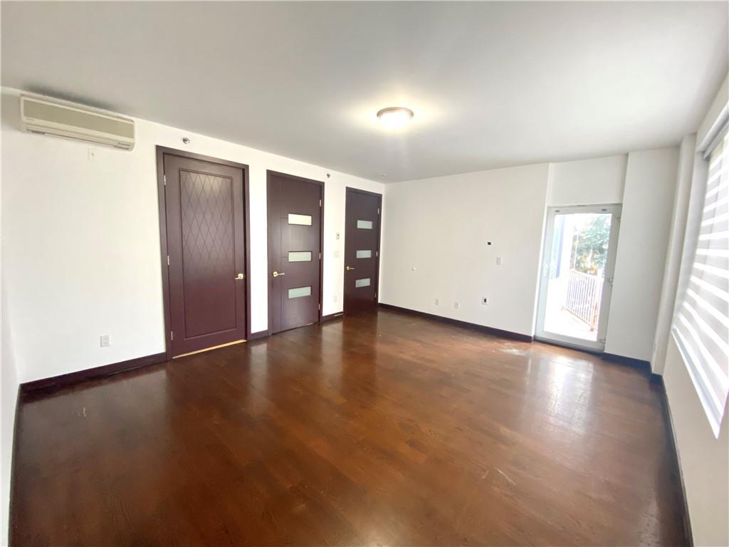 2409 Avenue Z, Unit 202 Brooklyn, NY 11235 - Photo 17 of 26 an empty room with wooden floor and windows with curtains