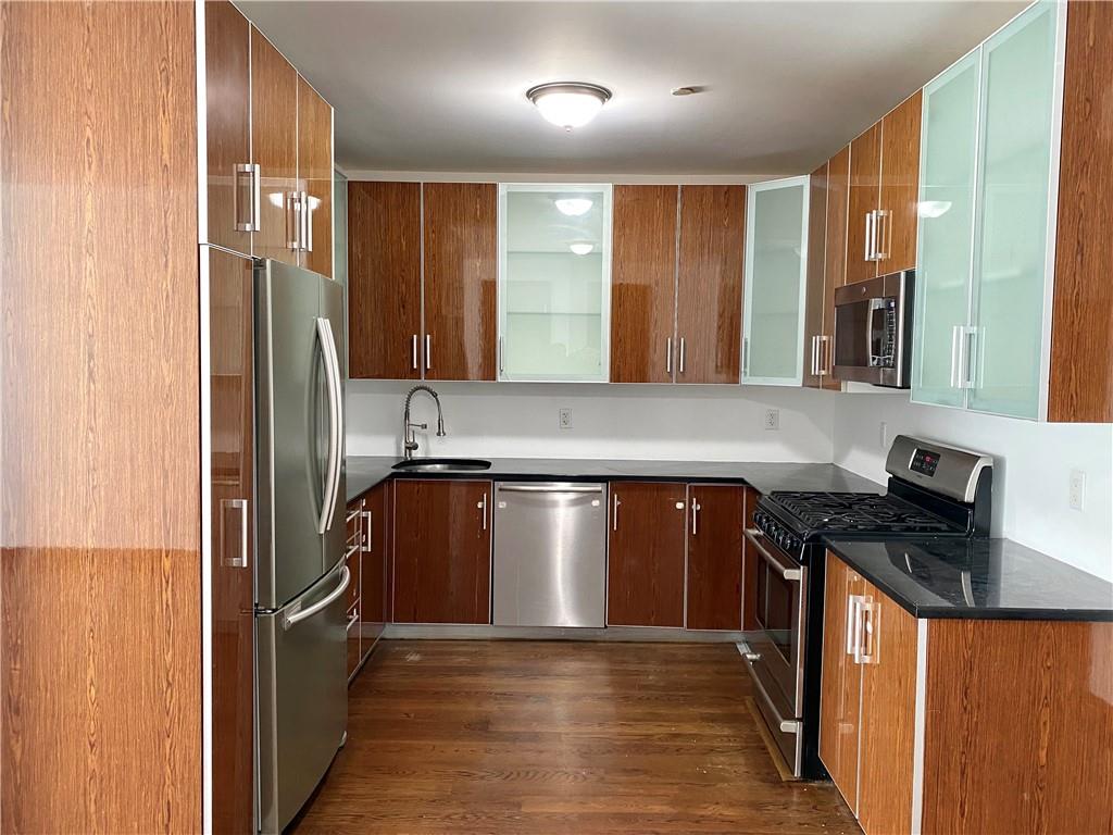 2409 Avenue Z, Unit 202 Brooklyn, NY 11235 - Photo 3 of 26 a kitchen with stainless steel appliances granite countertop a refrigerator a sink and wooden cabinets