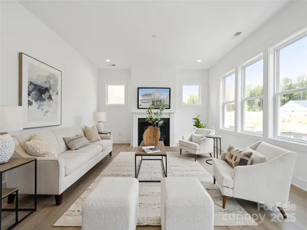 a living room with furniture two window and a couch