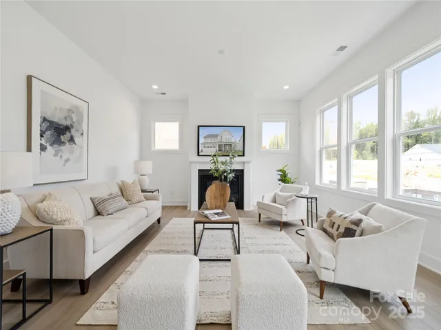 a living room with furniture two window and a couch