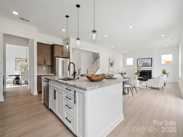 a kitchen with stainless steel appliances granite countertop a stove and a wooden floors
