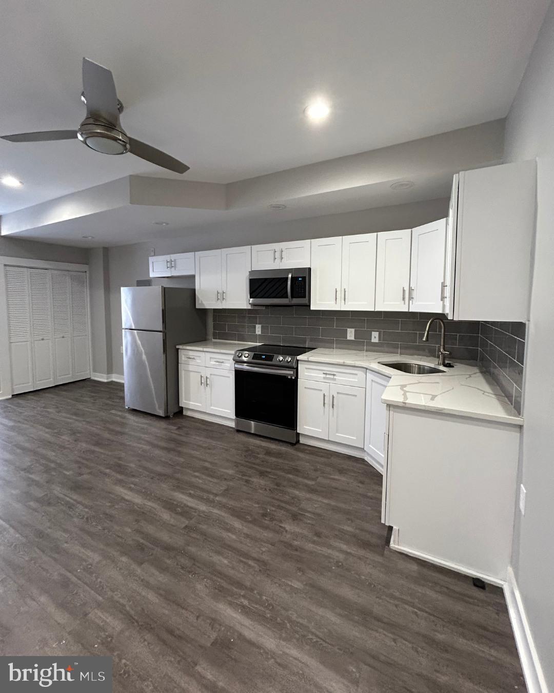 633 Lindley Avenue, Unit 2RF Philadelphia, PA 19120 - Photo 2 of 7 a kitchen with granite countertop a refrigerator stove top oven and sink