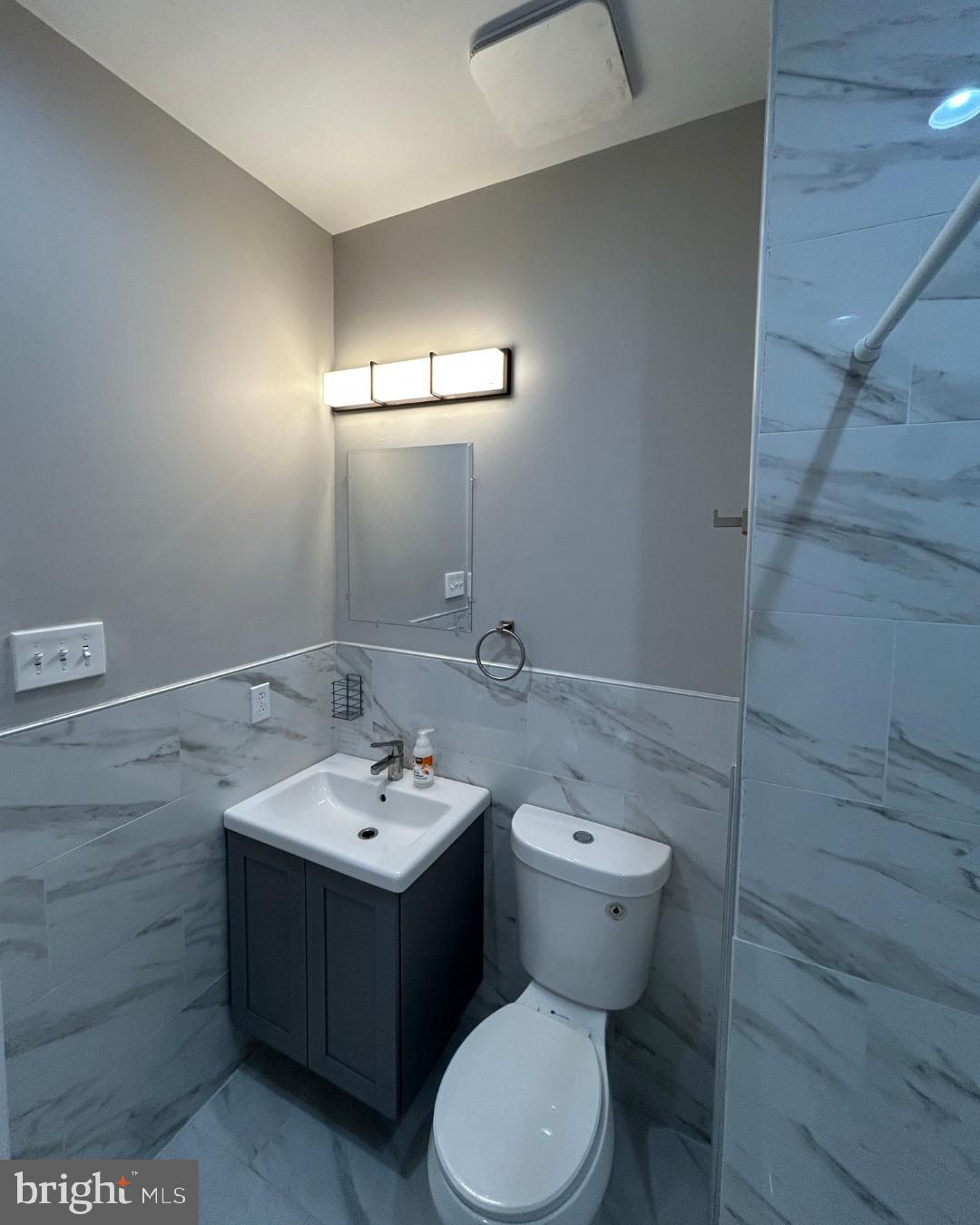 633 Lindley Avenue, Unit 2RF Philadelphia, PA 19120 - Photo 6 of 7 a bathroom with a toilet sink and mirror