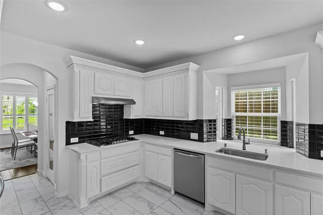 a kitchen with stainless steel appliances a sink stove and cabinets