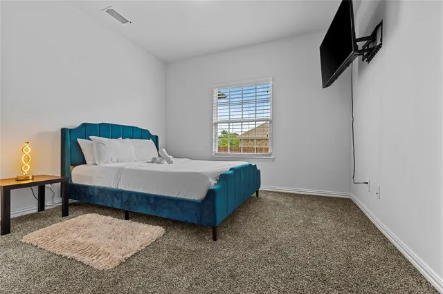 a bed sitting in a bedroom next to a window