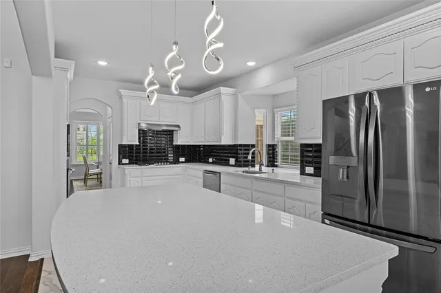 a kitchen with stainless steel appliances a refrigerator sink and microwave