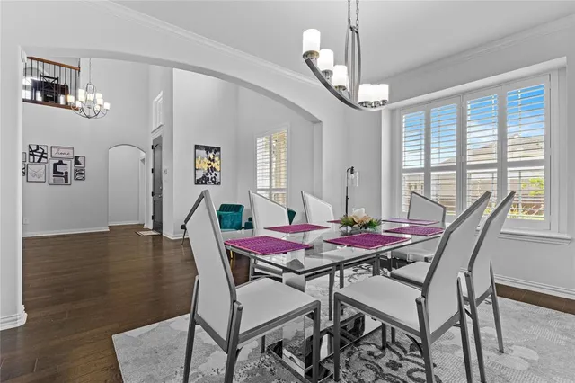 a dining room with furniture a chandelier and wooden floor