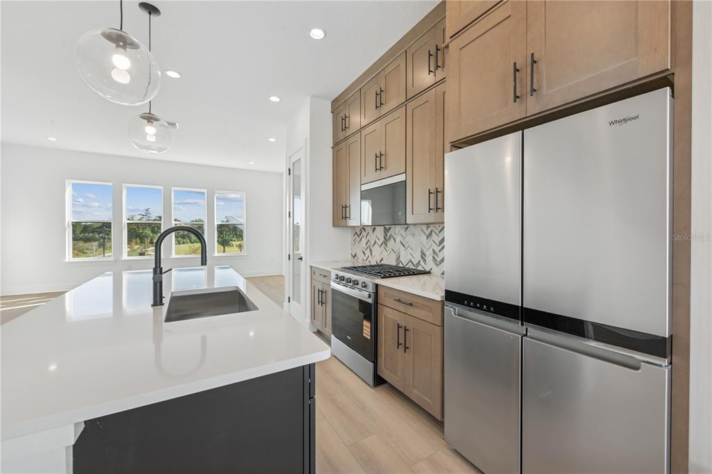 2224 Brix Street Orlando, FL 32804 - Photo 8 of 36 a kitchen with kitchen island white cabinets and white appliances