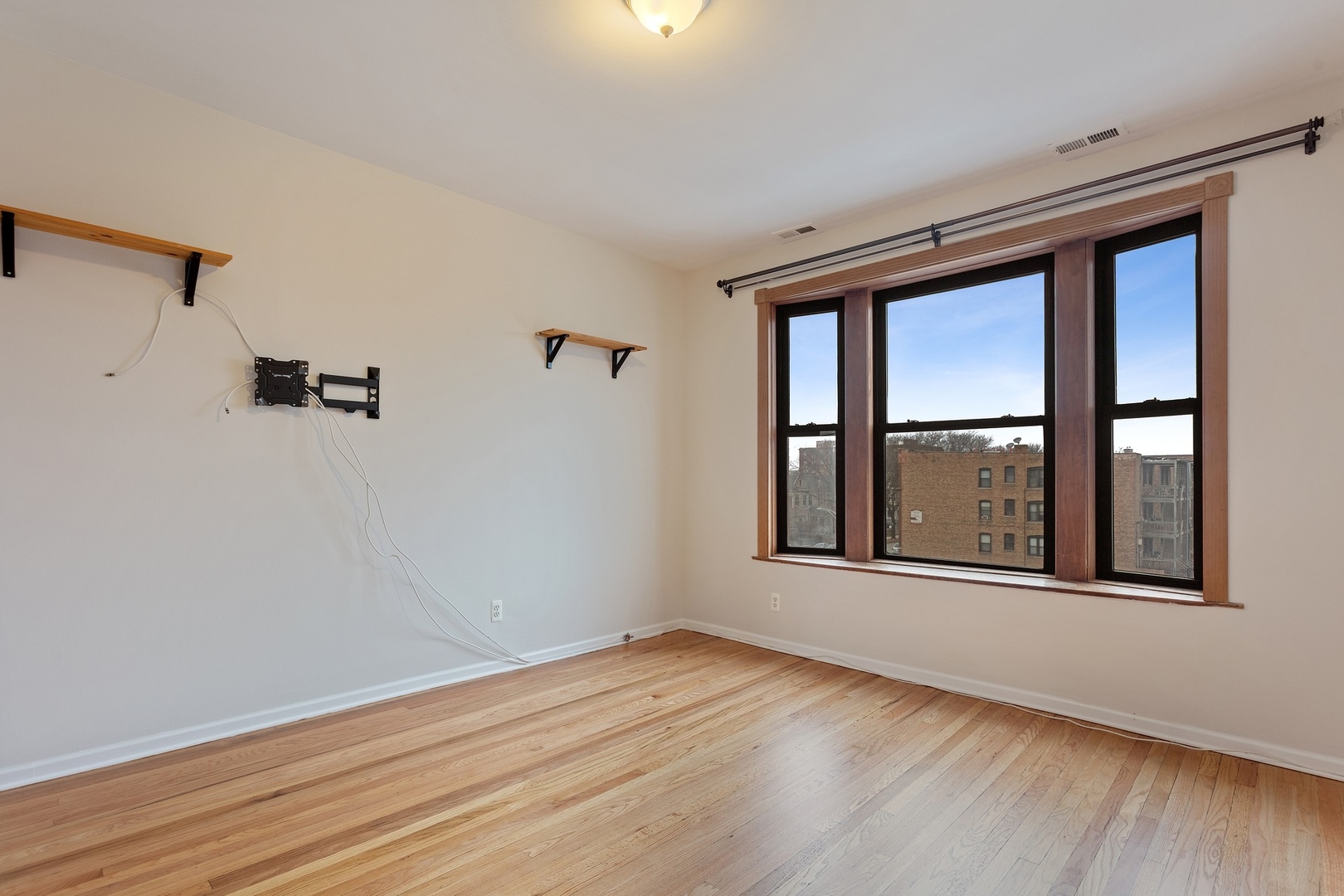 1409 East 62nd Street, Unit 3 Chicago, IL 60637 - Photo 3 of 10 an empty room with wooden floor and windows