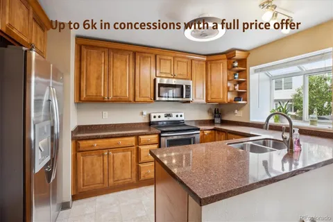 a kitchen with stainless steel appliances granite countertop a sink and a refrigerator