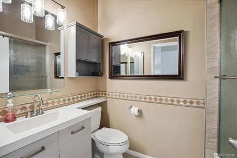 a bathroom with a toilet a sink and mirror