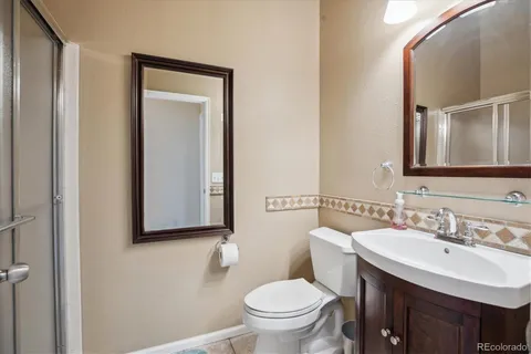 a bathroom with a toilet sink vanity and mirror