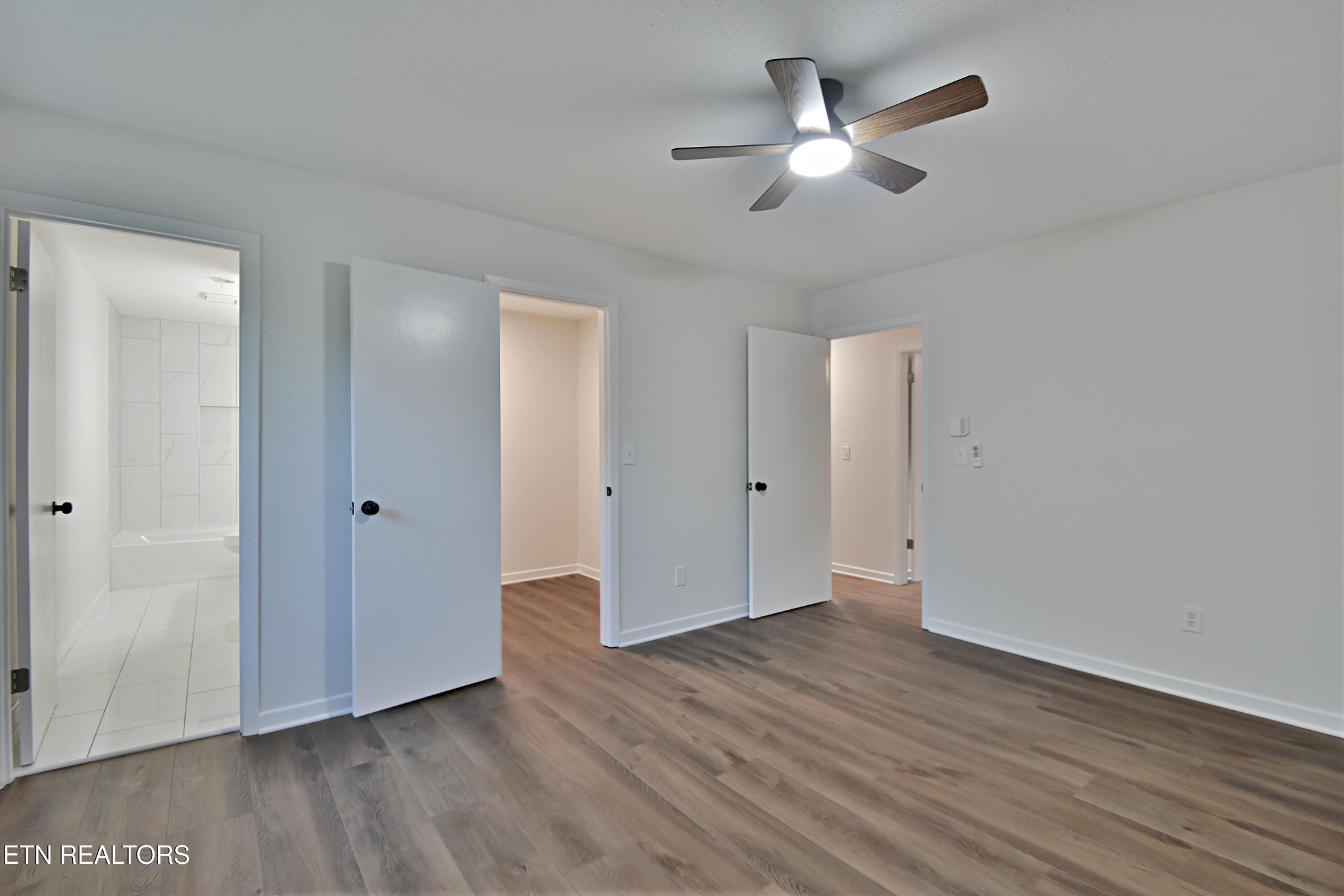 1119 Rudd Road Greenback, TN 37742 - Photo 17 of 28 an empty room with wooden floor and a ceiling fan