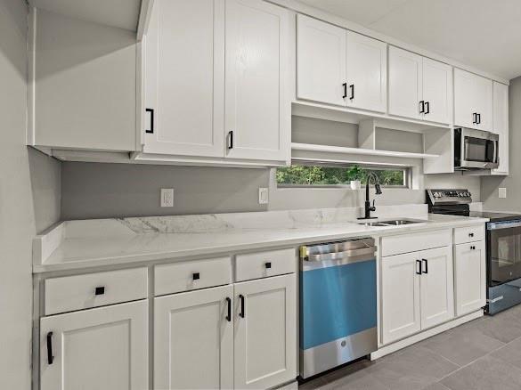 1301 East 9th Street Mount Pleasant, TX 75455 - Photo 9 of 26 a kitchen with white cabinets and a sink