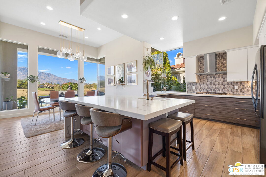 182 Loch Lomond Road Rancho Mirage, CA 92270 - Photo 17 of 48 a kitchen with stainless steel appliances granite countertop a kitchen island a stove a table and chairs