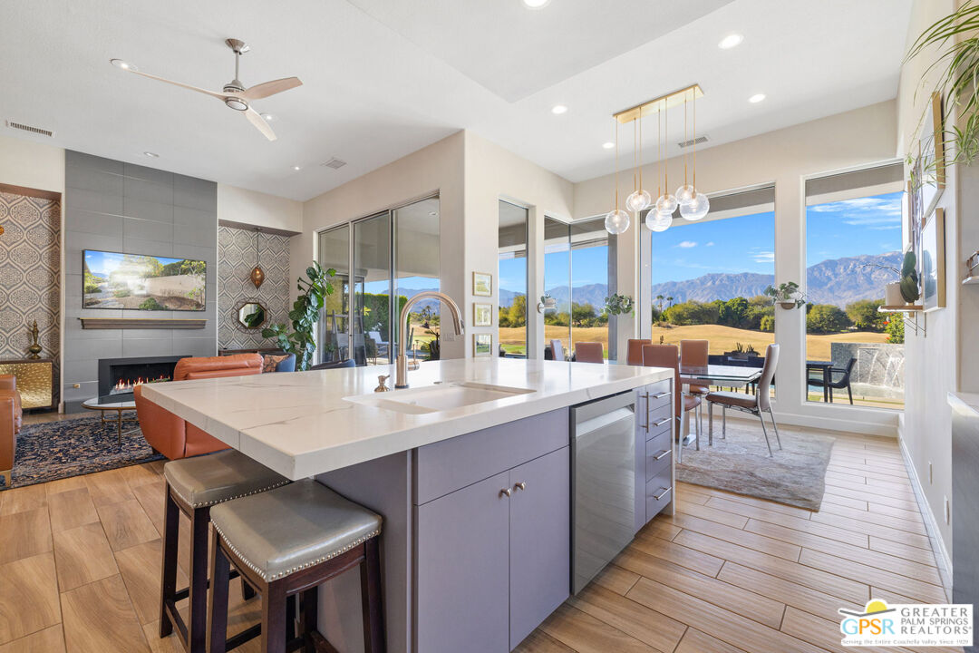 182 Loch Lomond Road Rancho Mirage, CA 92270 - Photo 6 of 48 a kitchen with stainless steel appliances kitchen island granite countertop a table chairs and a refrigerator