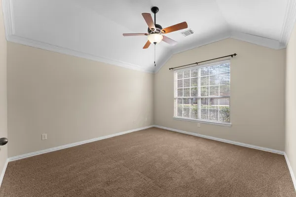 a view of an empty room with wooden floor and a fireplace