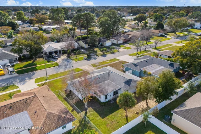an aerial view of residential houses with outdoor space and swimming pool