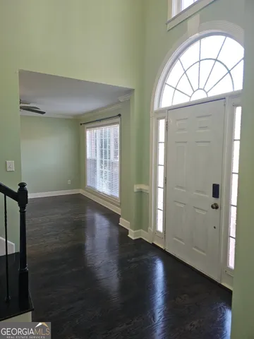 a view of a livingroom with wooden floor staircase and a chandelier