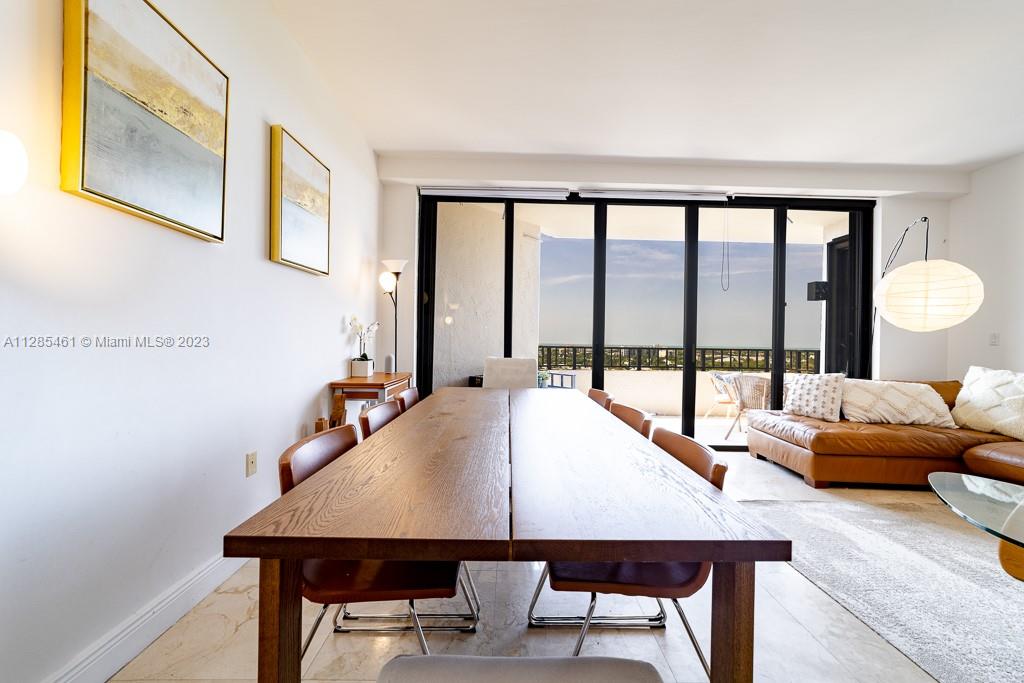 151 Crandon Boulevard, Unit 1023 Key Biscayne, FL 33149 - Photo 24 of 55 a view of a dining room with furniture a chandelier and wooden floor