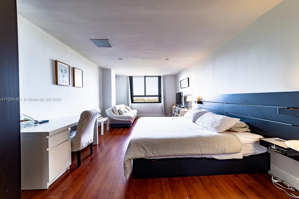 151 Crandon Boulevard, Unit 1023 Key Biscayne, FL 33149 - Photo 28 of 55 a bedroom with a bed and wooden floor