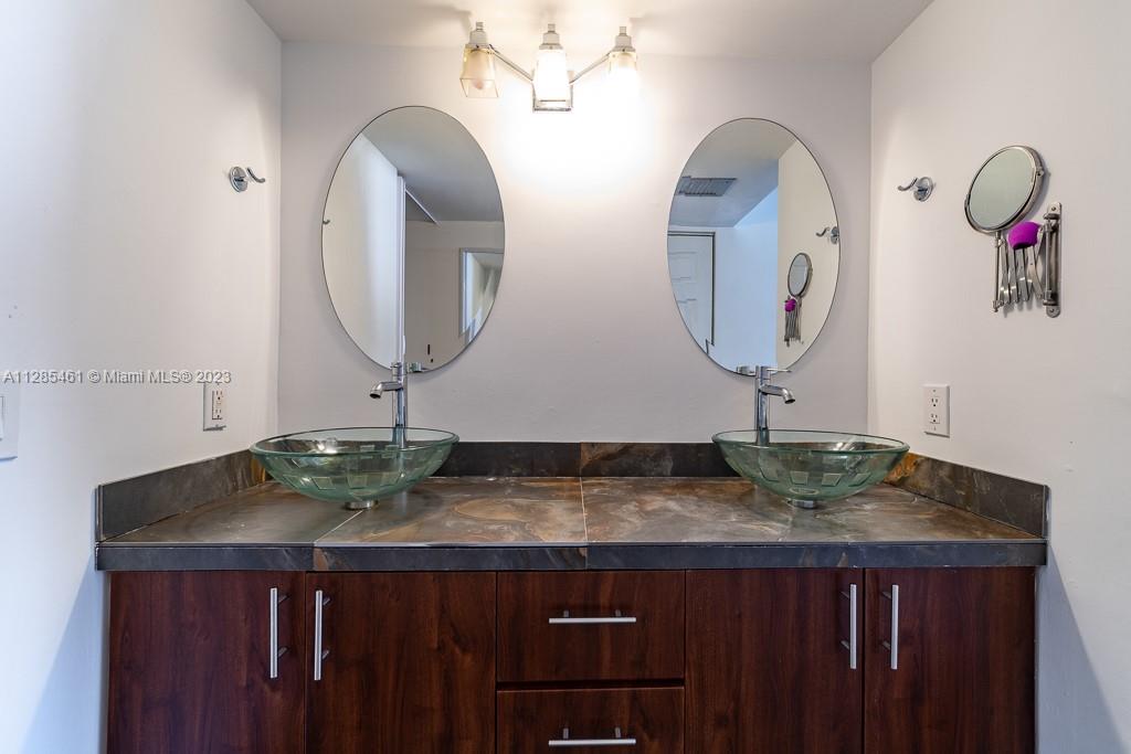 151 Crandon Boulevard, Unit 1023 Key Biscayne, FL 33149 - Photo 37 of 55 a bathroom with a granite countertop sink and a mirror