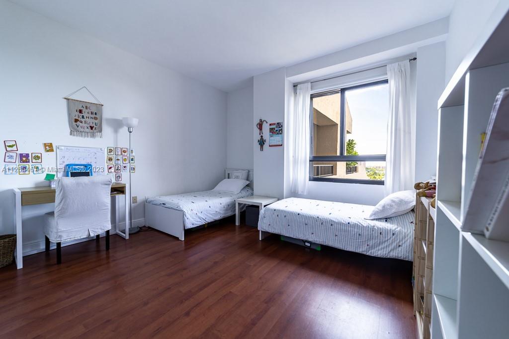 151 Crandon Boulevard, Unit 1023 Key Biscayne, FL 33149 - Photo 41 of 55 a bedroom with two beds and wooden floor