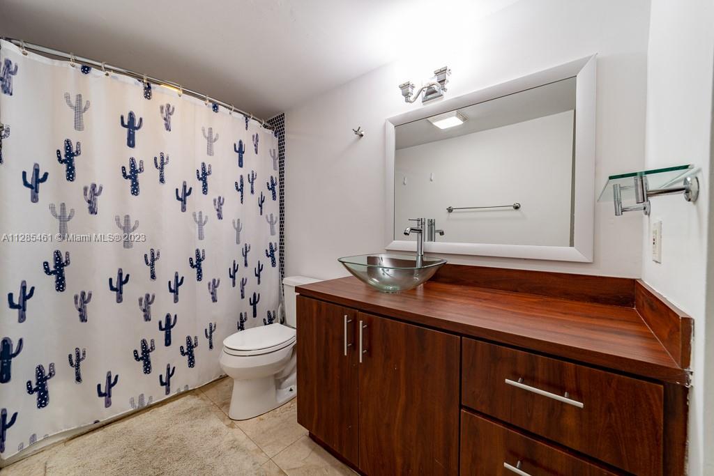 151 Crandon Boulevard, Unit 1023 Key Biscayne, FL 33149 - Photo 46 of 55 a bathroom with a granite countertop sink a toilet and a mirror