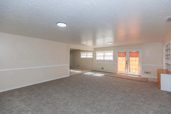 an empty room with windows and closet