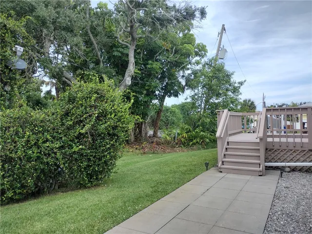 a view of a wooden deck and a yard with trees