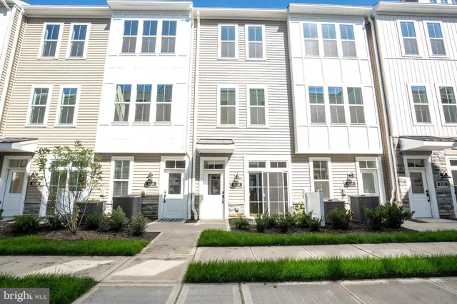 a front view of a residential apartment building with a yard