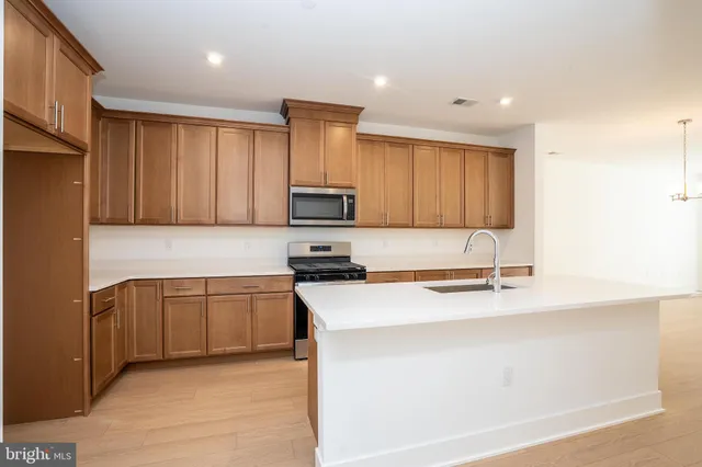 a kitchen with stainless steel appliances granite countertop a sink stove and microwave