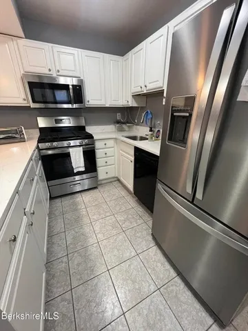 a kitchen with stainless steel appliances and countertop refrigerator sink