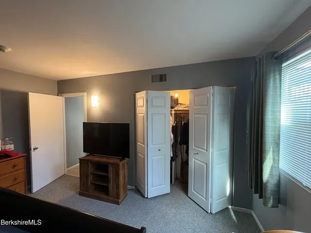 a living room with a flat screen tv and a refrigerator