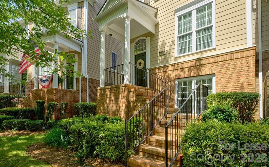 1104 Drayton Court Fort Mill, SC 29708 - Photo 2 of 20 a view of a brick house with a large windows and flower plants